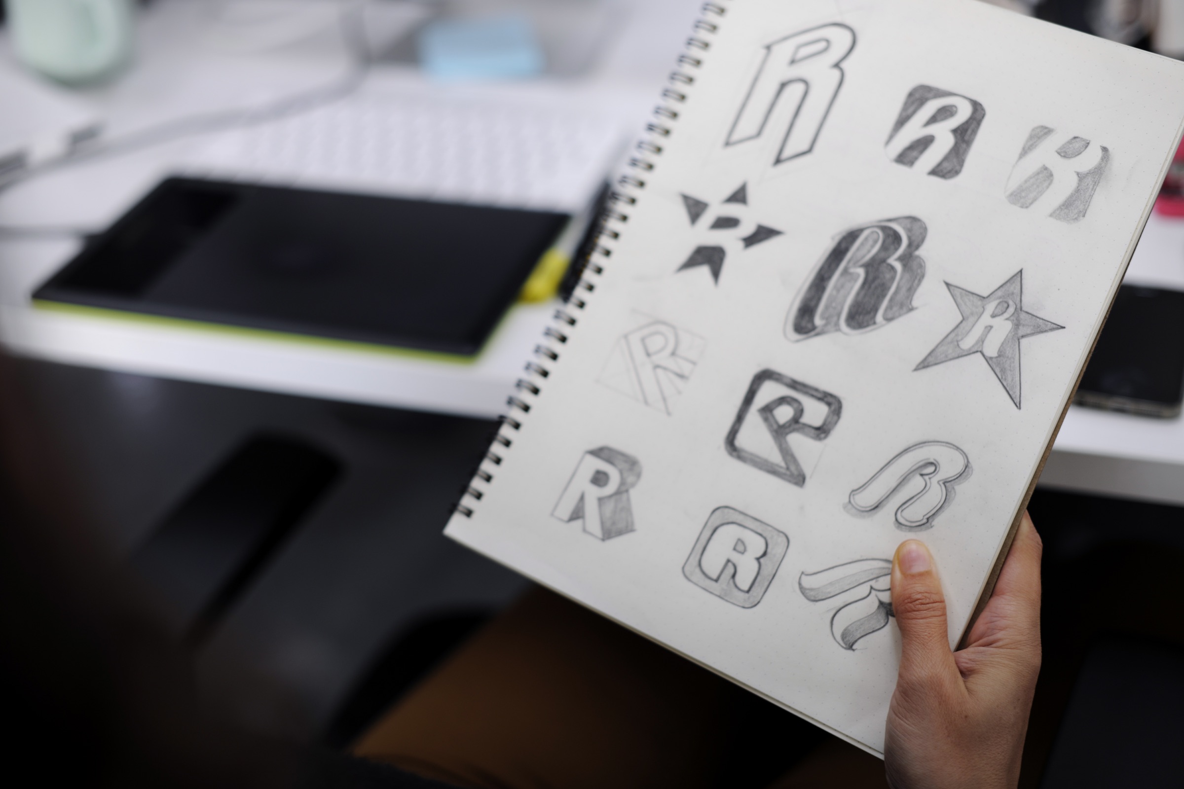 Sketchbook containing a series of exploratory logo concepts